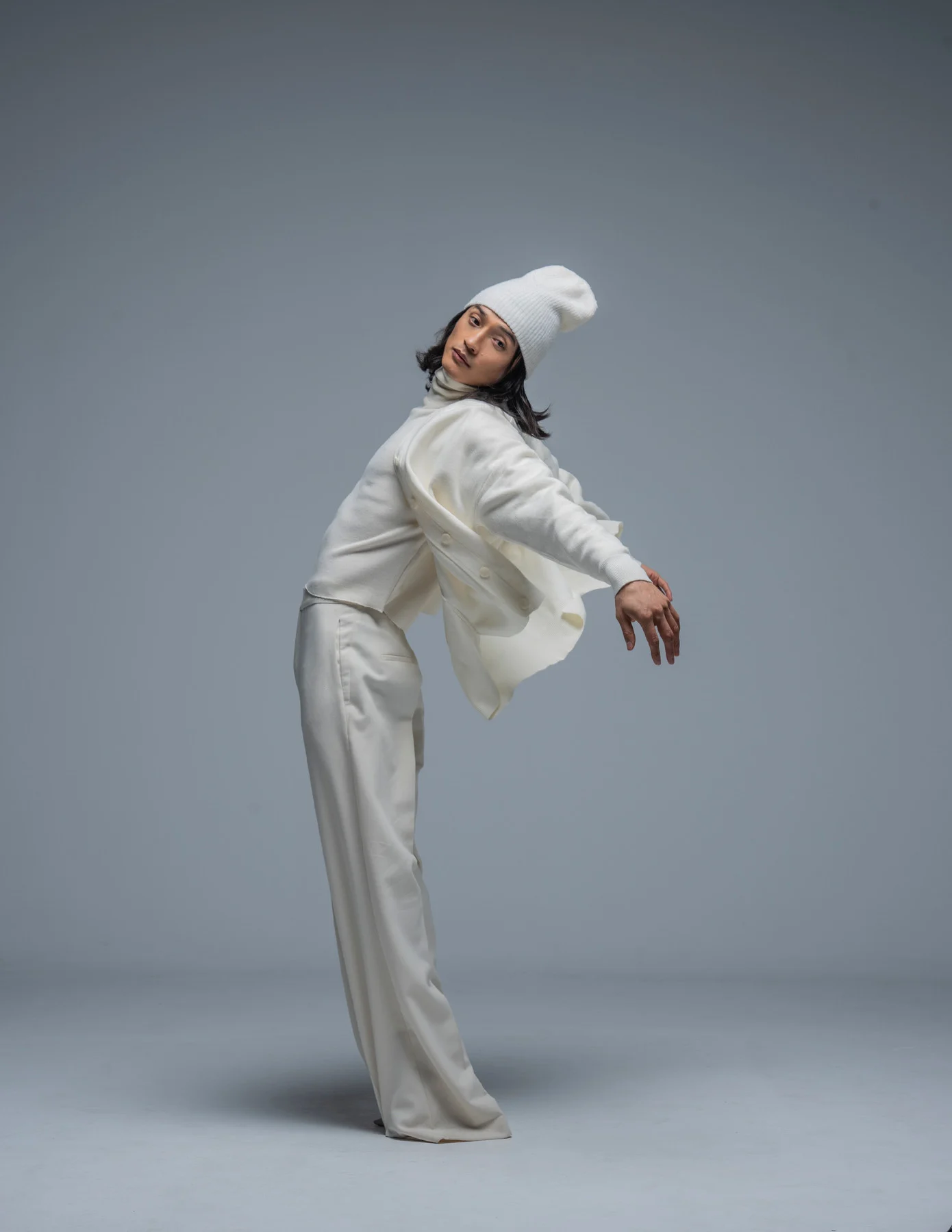 Ochir modelling a white outfit in a quiet, sculptural studio pose